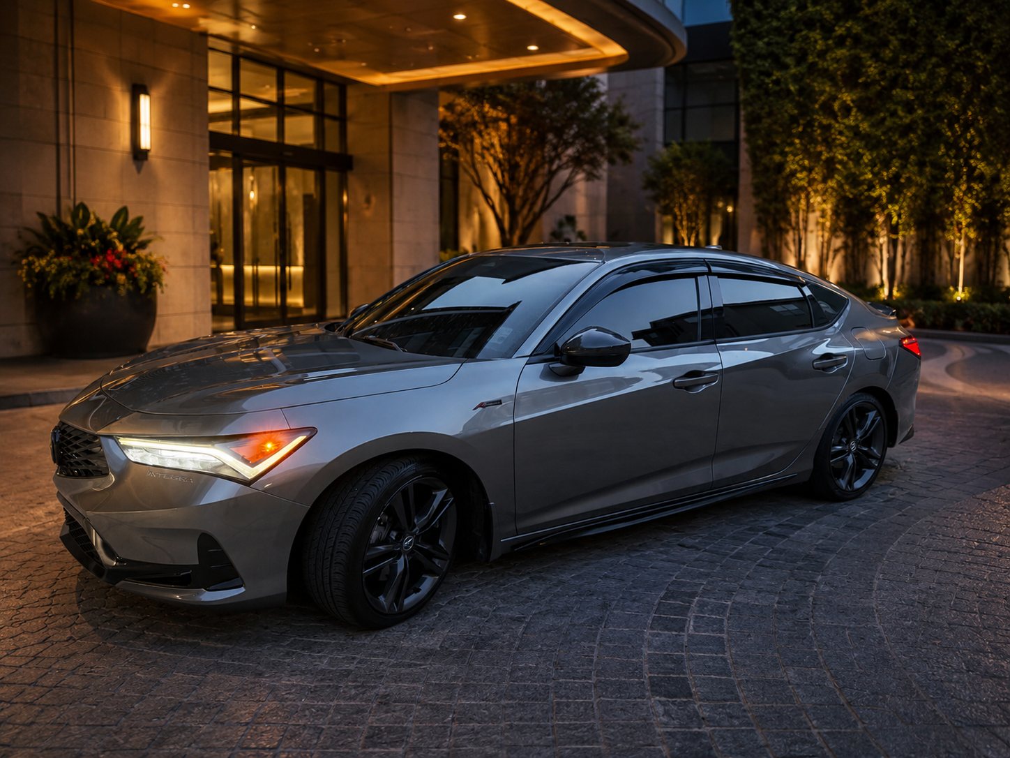 Gray Acura Integra A-Spec used by Northshore Elite Services parked at an upscale building entrance at dusk